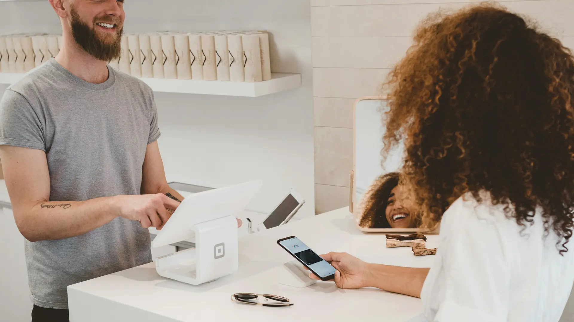Shop assistant serving a customer paying at the counter