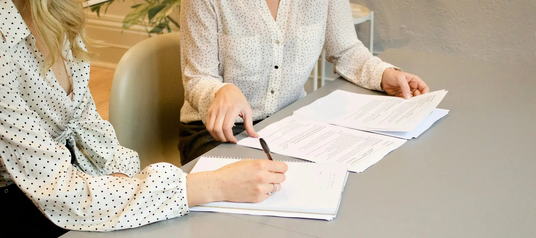 Two people reviewing supplier proposals at a table
