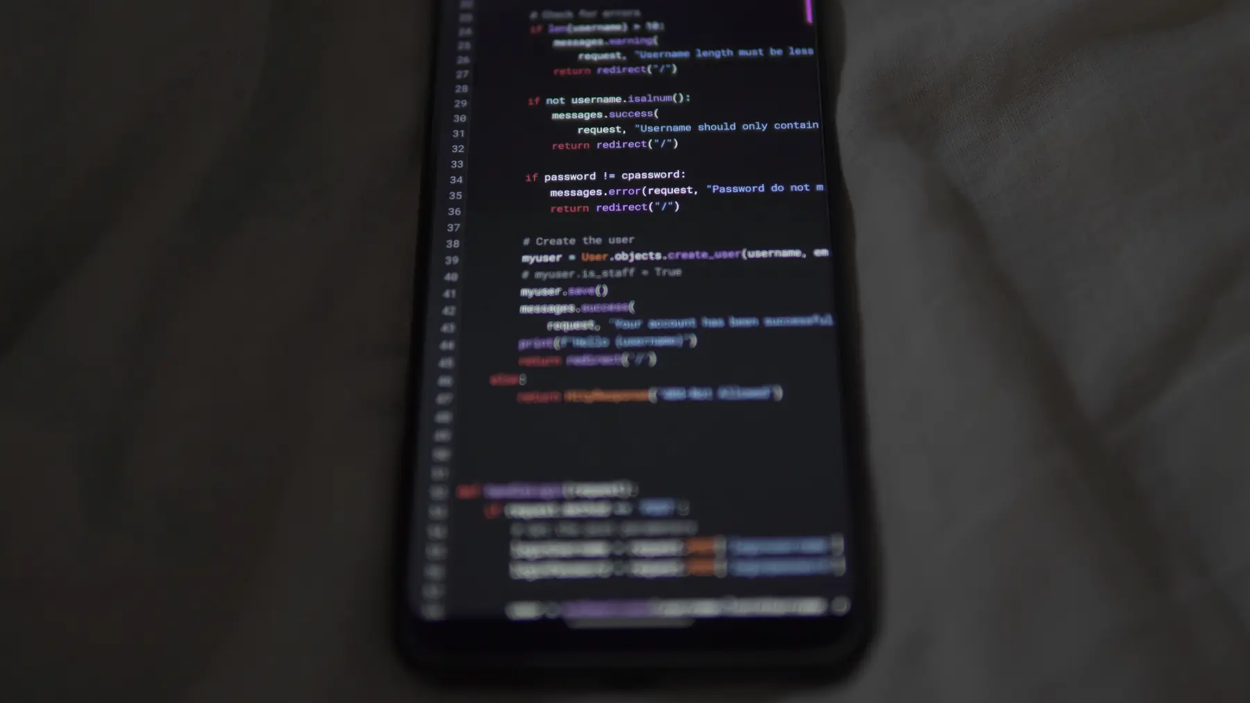 Mobile app being used on a phone with a laptop in the background