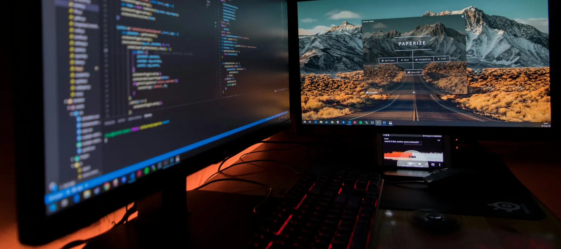 Developer working on application code with a dashboard on a second monitor