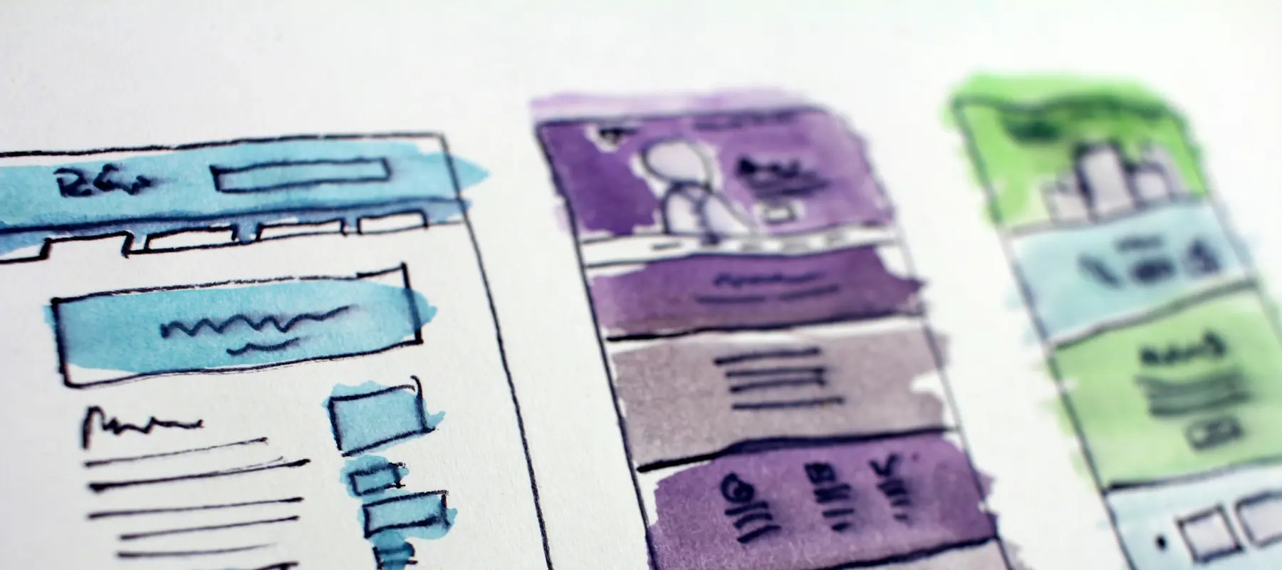 Website wireframes and a design system laid out on a desk